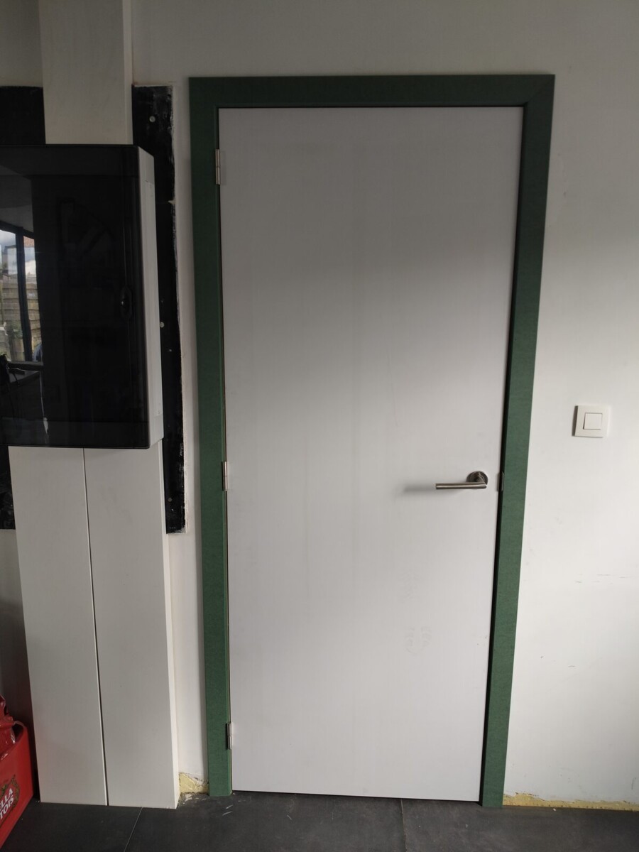 Witte binnendeur met groene omlijsting naast een kast op maat Witte binnendeur met groene omlijsting naast een kast op maat