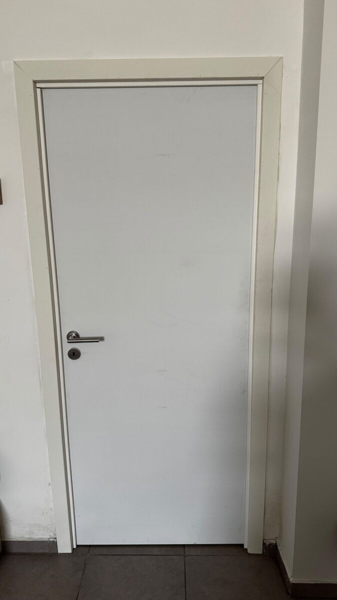 Witte binnendeur op maat met omlijsting in een gang Witte binnendeur op maat met omlijsting in een gang