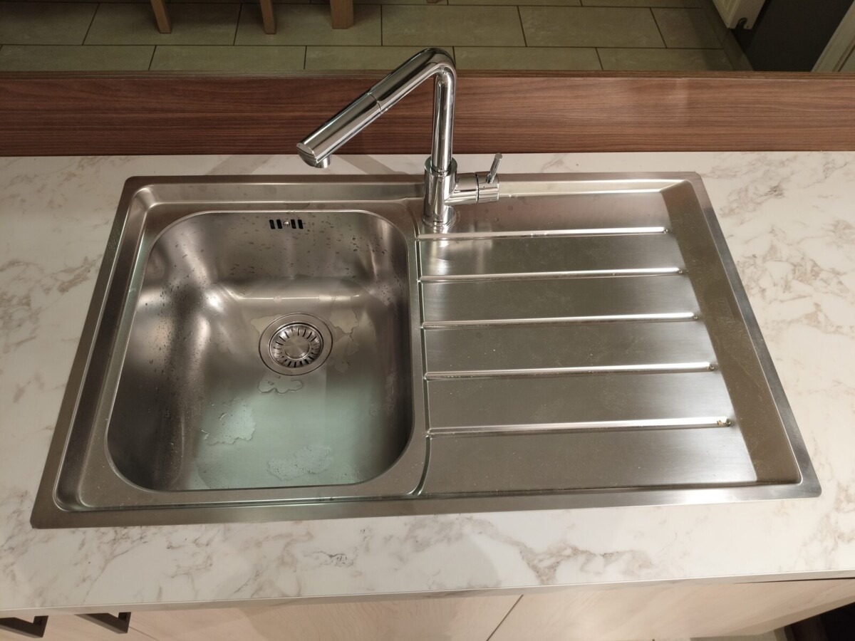 Rvs spoelbak met hoge kraan in een keukenwerkblad in marmerlook Rvs spoelbak met hoge kraan in een keukenwerkblad in marmerlook